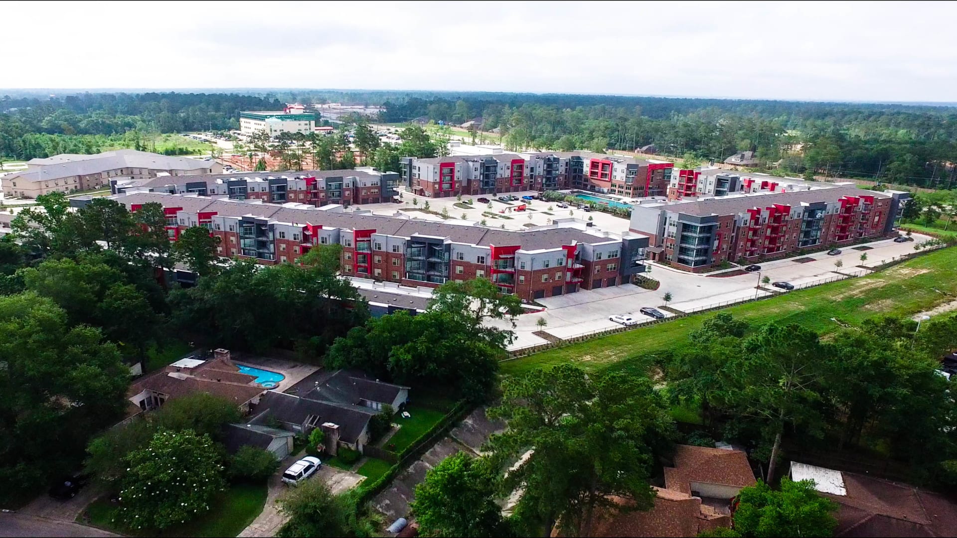 an aerial view of a residential complex with trees and green grass at The Anatole at  Pines