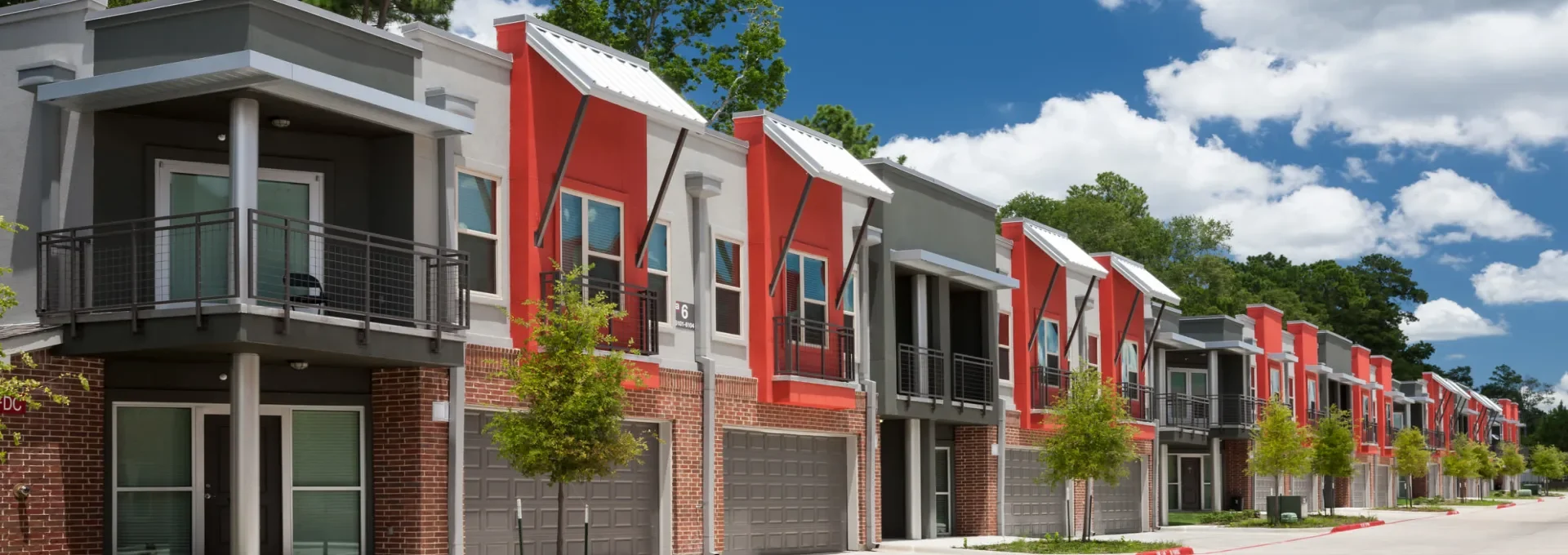 the exterior of a row of townhomes in a residential neighborhood at The Anatole at  Pines