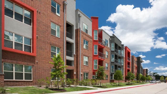 the exterior of an apartment complex with red and blue windows at The Anatole at  Pines